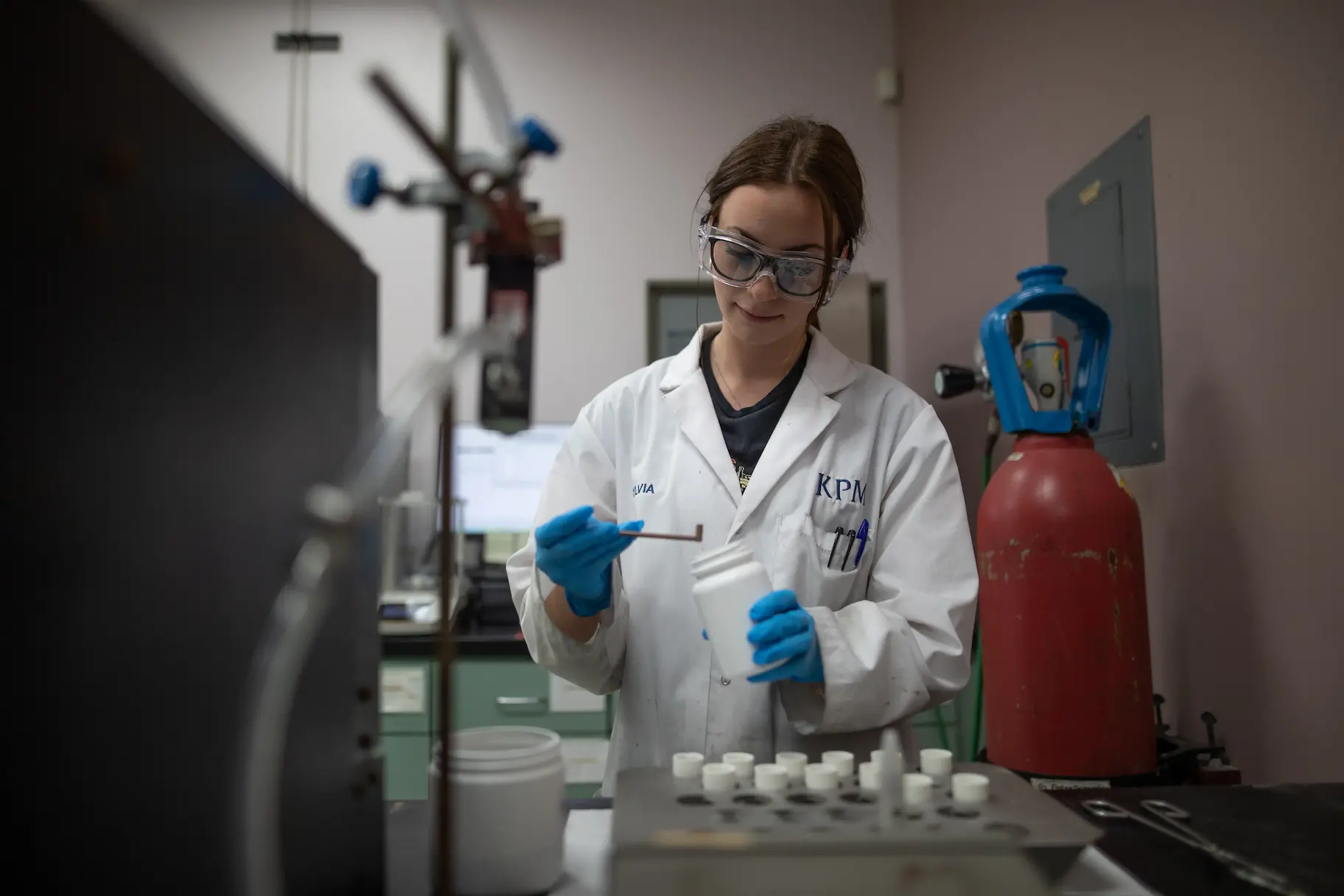 a KPM employee in a lab coat performing a test