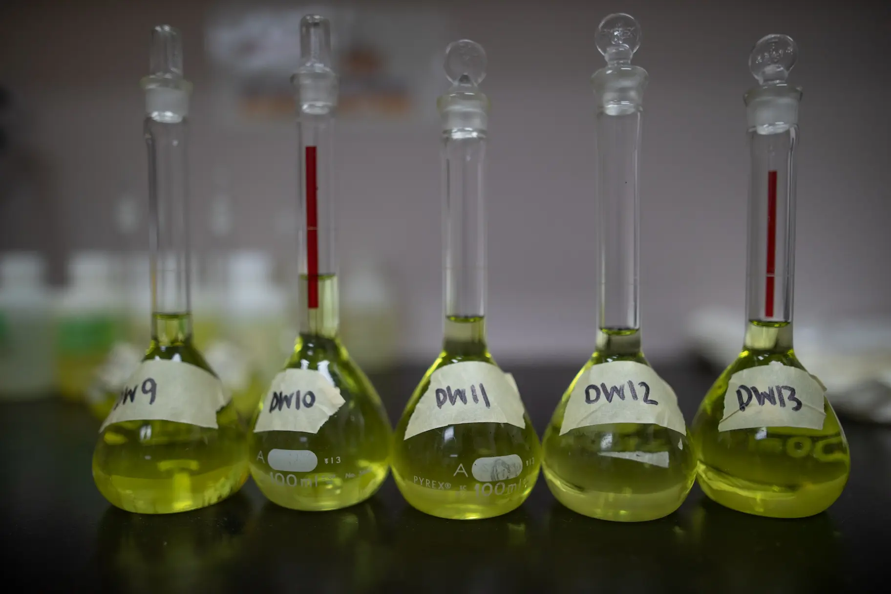 different lab tests with test tubes containing green liquid